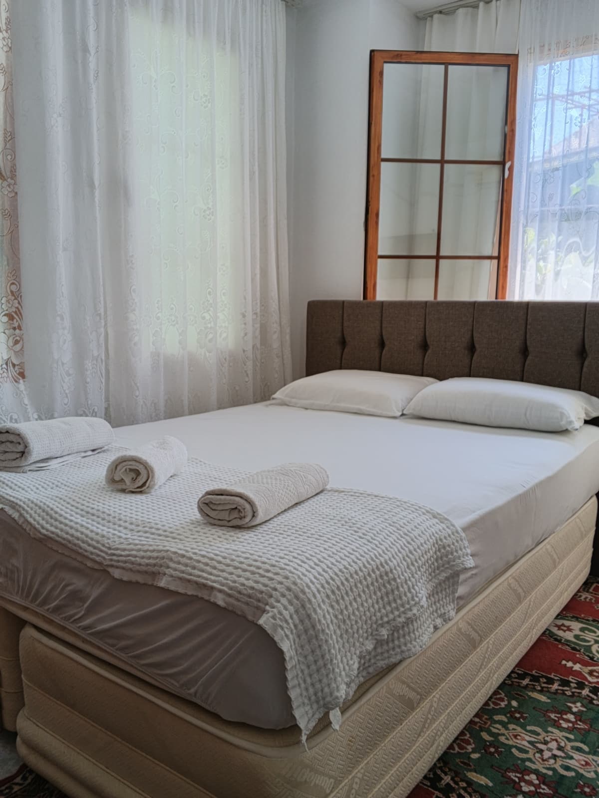 Pencereli iki kişilik oda ve hazırlanmış havlular